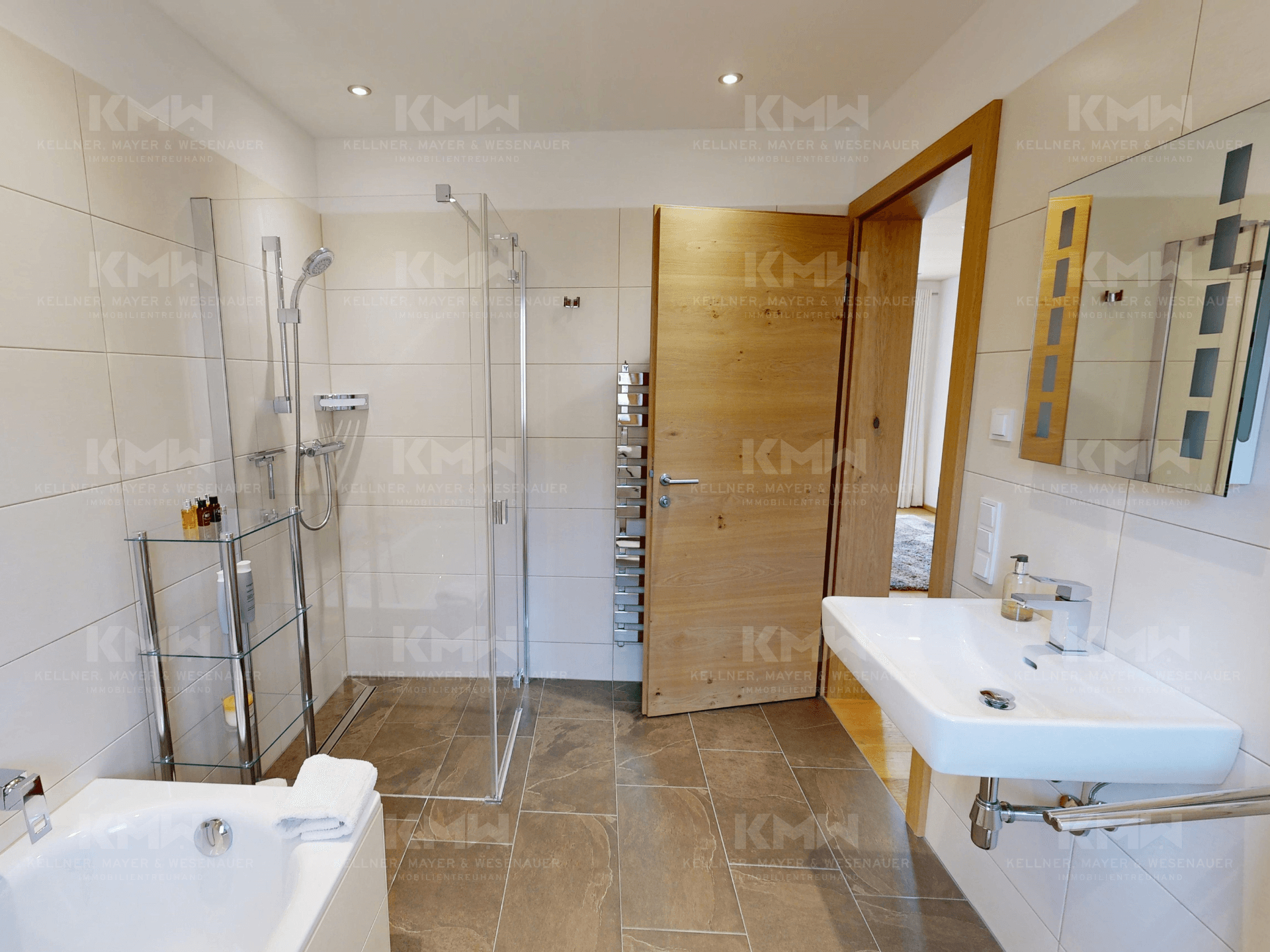 Geräumiges Badezimmer mit Badewanne, Dusche, modernem Waschbecken und Holztür.