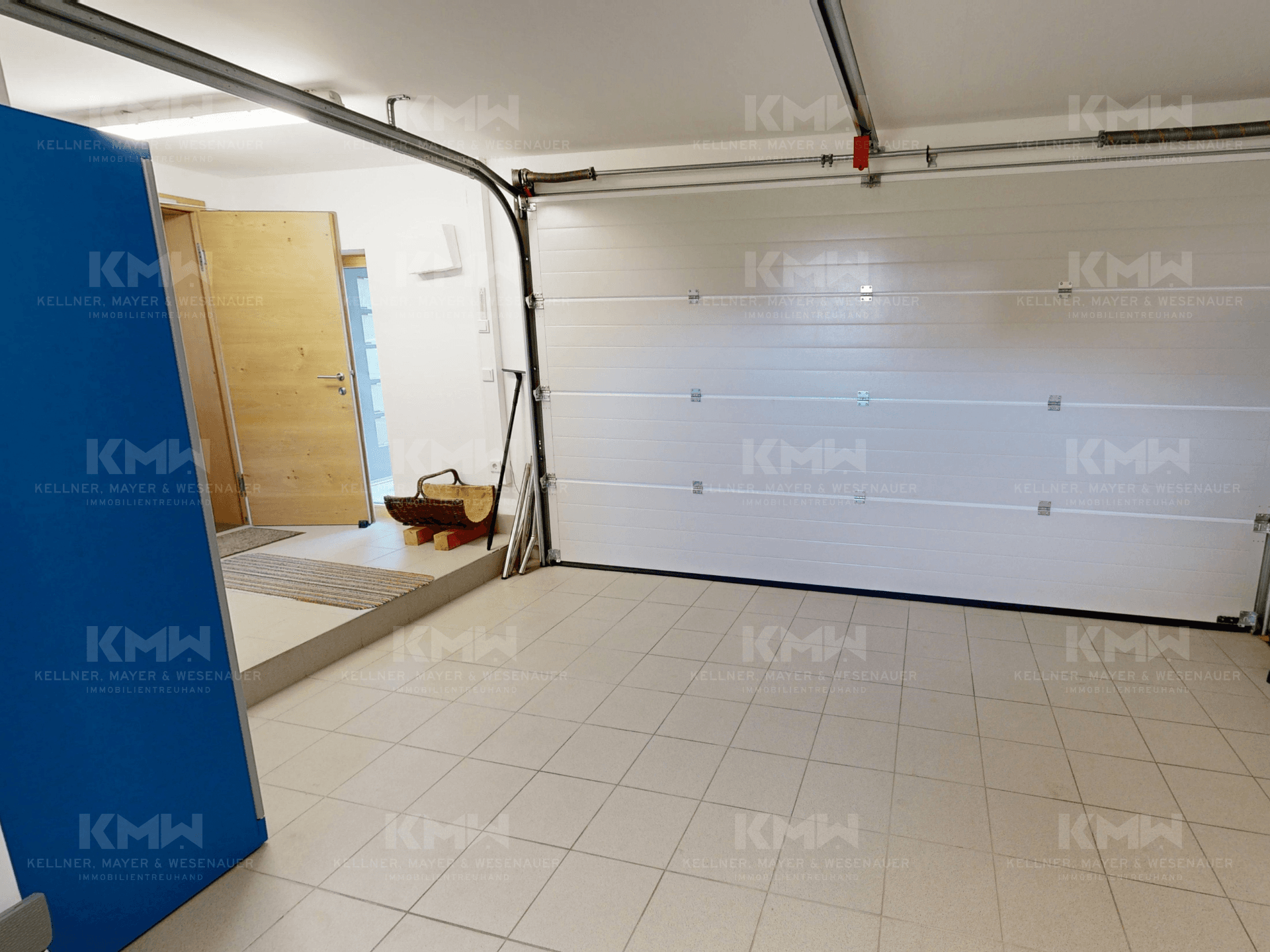 Geräumige Garage mit Fliesenboden und Zugang zum Innenbereich des Hauses.
