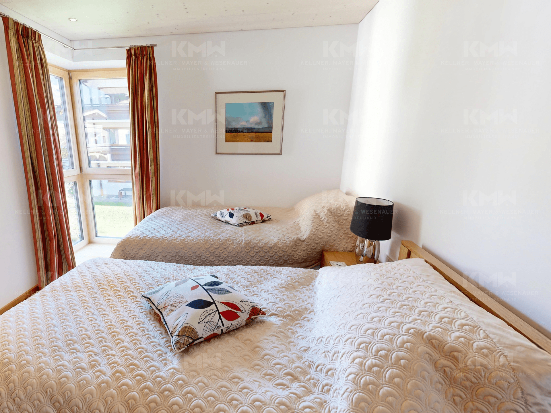 Helles Schlafzimmer mit zwei Einzelbetten, Holzboden und Fenster mit Ausblick.