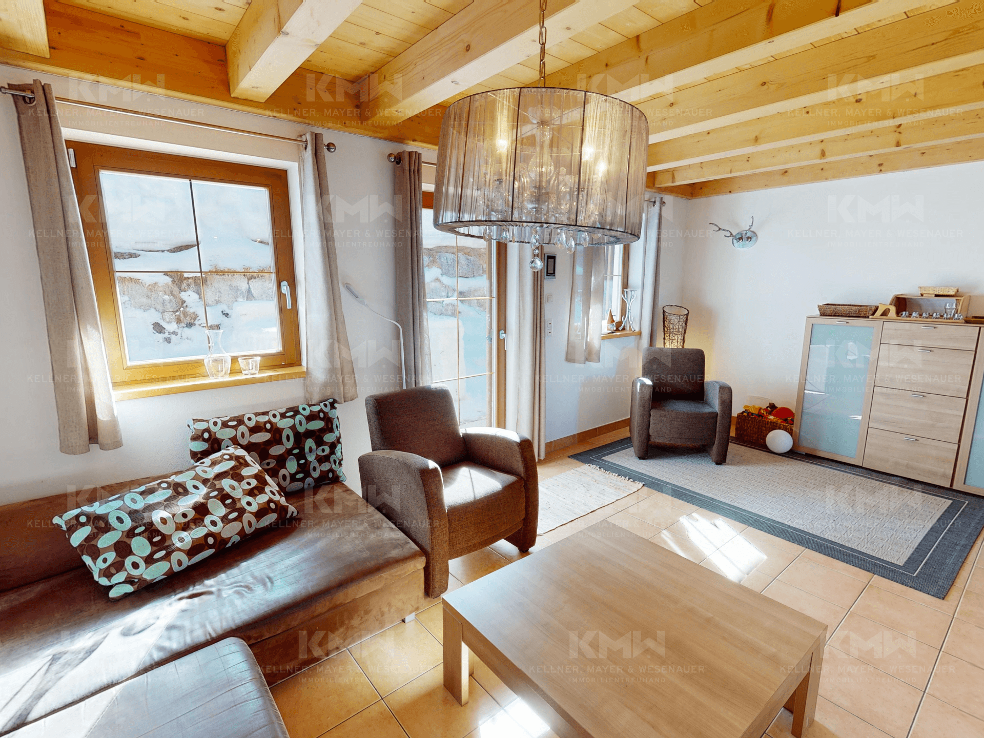 Gemütliches Wohnzimmer mit bequemen Sofas, Holzbalkendecke und viel natürlichem Licht.