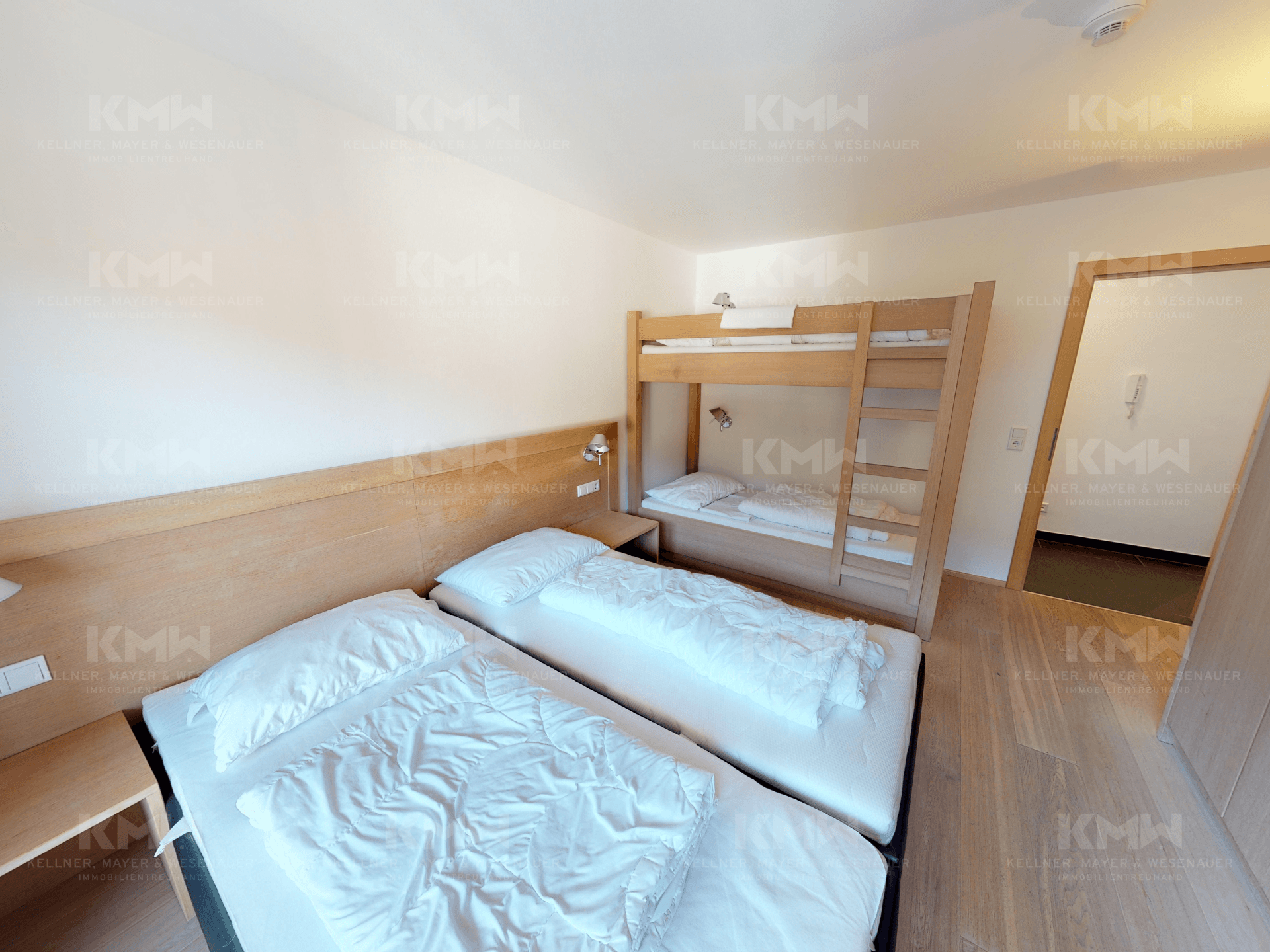 Gemütliches Schlafzimmer mit zwei Einzelbetten und einem Etagenbett, ideal für Familien.