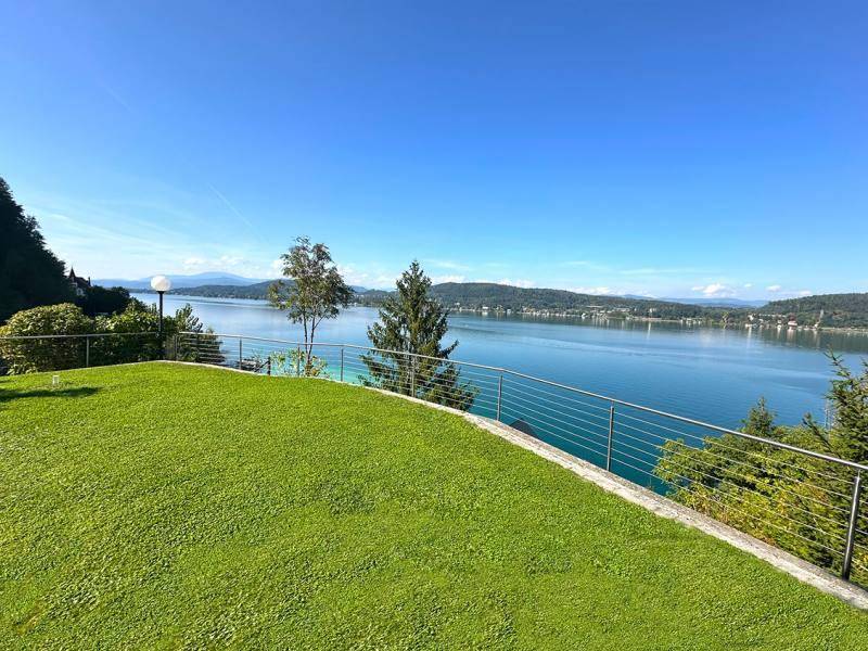 Gepflegte Rasenfläche mit moderner Reling und weitem Blick über den See und die umliegende Landschaft.