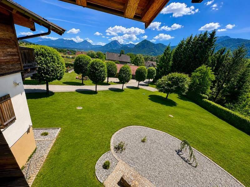 Weitläufiger grüner Garten mit gepflegtem Rasen und Panoramablick auf die Berge.