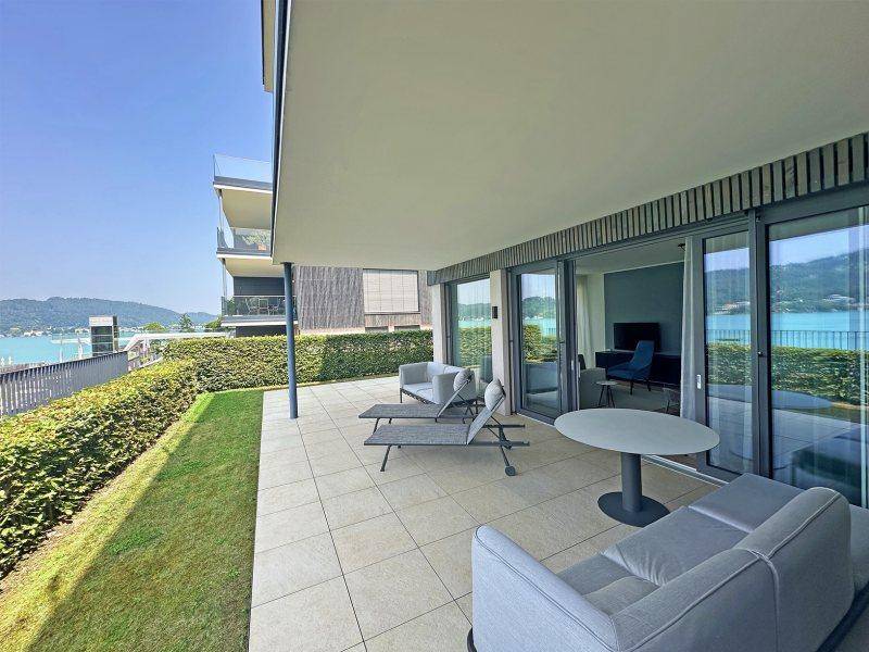 Großzügige überdachte Terrasse mit Fliesenboden und Seeblick, ideal für entspannte Stunden.