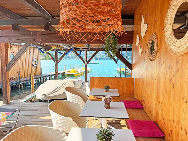 Gemütlicher Sitzbereich mit Holzwänden und Blick auf den See, ideal zum Entspannen.