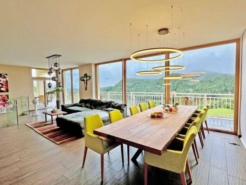 Geräumiger Wohn- und Essbereich mit bodentiefen Fenstern, modernem Design und Panoramablick.