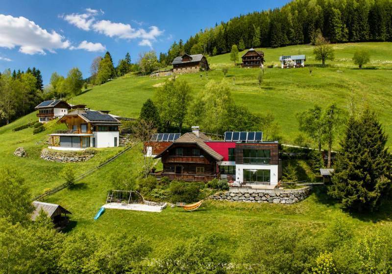 Weitläufiges Anwesen mit mehreren Häusern in einer idyllischen Berglandschaft mit viel Grün.