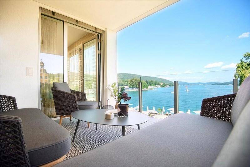 Gemütlicher Balkon mit modernen Loungemöbeln und einem atemberaubenden Blick auf den See.