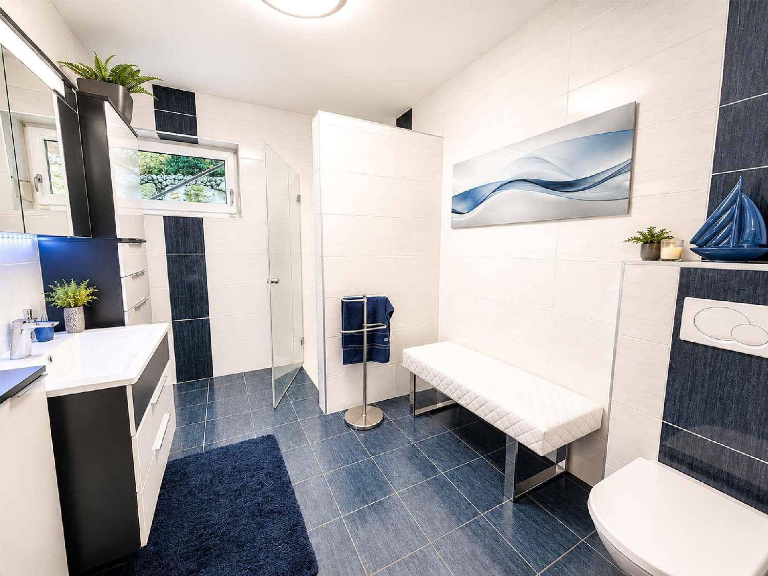 Modernes Badezimmer mit Doppelwaschbecken, Dusche und blauen Akzenten.