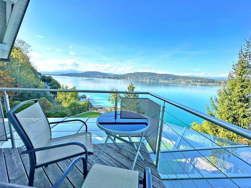 Gemütlicher Balkon mit Sitzgelegenheiten und atemberaubendem Blick auf den See und die Berge.