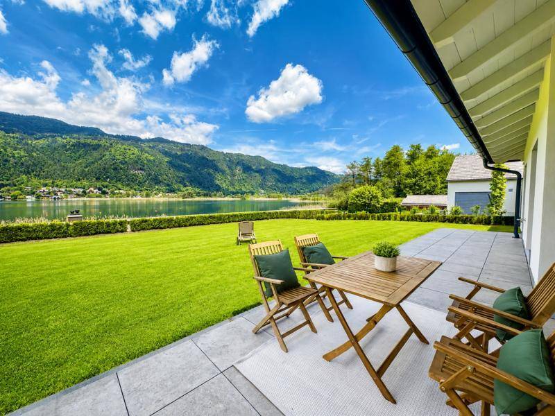 Geräumige Terrasse mit Sitzgelegenheiten und weitem Blick auf den See und die umliegenden Berge.