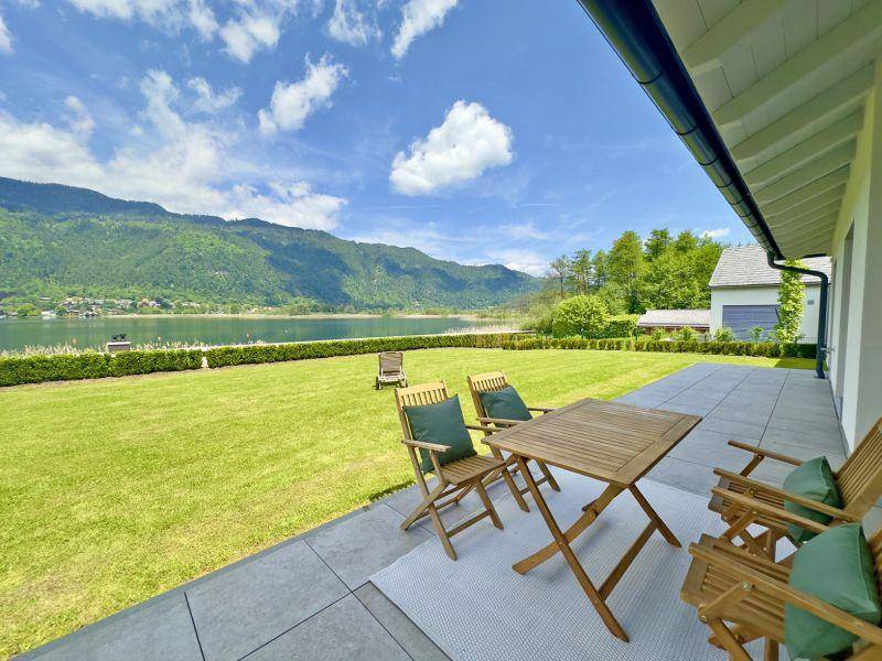 Geräumige Terrasse mit Sitzgelegenheiten und weitem Blick auf den See und die umliegenden Berge.