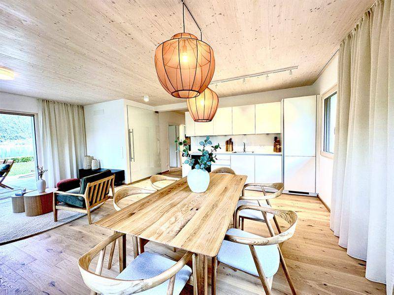 Moderner Essbereich mit Holztisch, Designerstühlen und Blick auf die Terrasse.