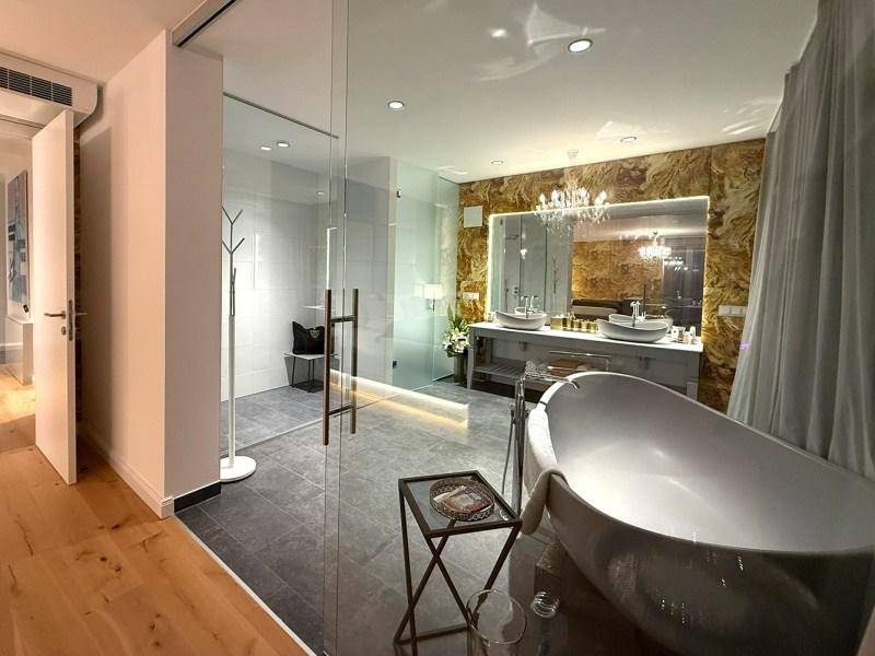 Geräumiges Badezimmer mit freistehender Badewanne, begehbarer Dusche und Doppelwaschbecken.