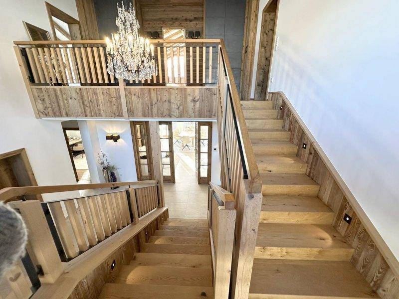 Elegante Holztreppe mit indirekter Beleuchtung, die verschiedene Ebenen des Hauses verbindet.