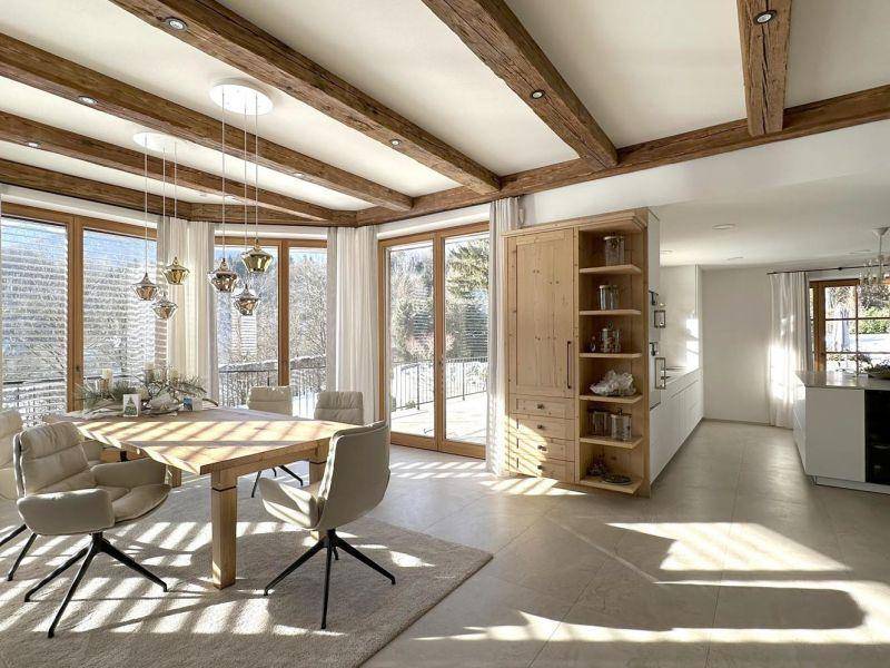 Offener Essbereich mit Holztisch und Stühlen, verbunden mit einer modernen Küche und Bergblick.