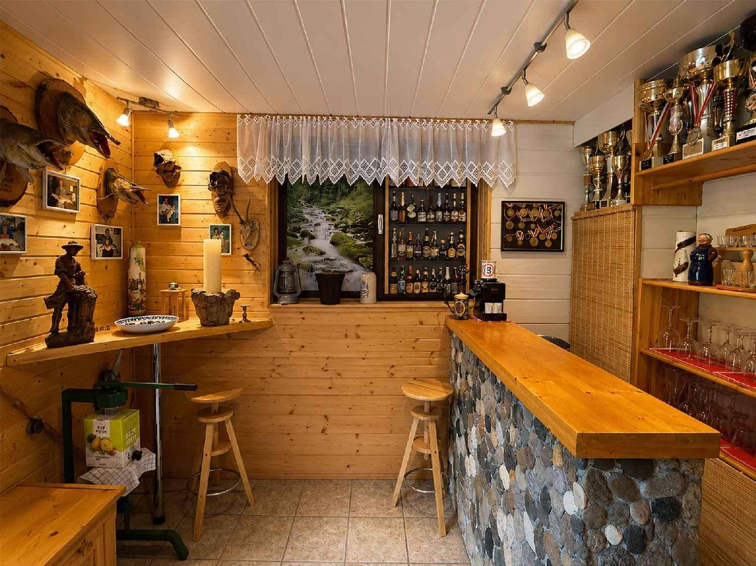 Gemütlicher Barbereich mit Holzvertäfelung, Fliesenboden und Trophäen.