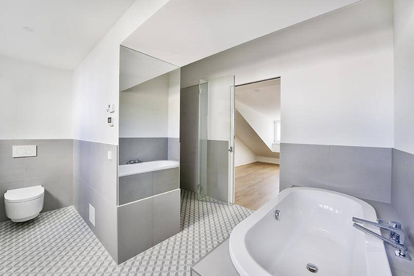 Modernes Badezimmer mit Badewanne, wandhängendem WC und separater Dusche.