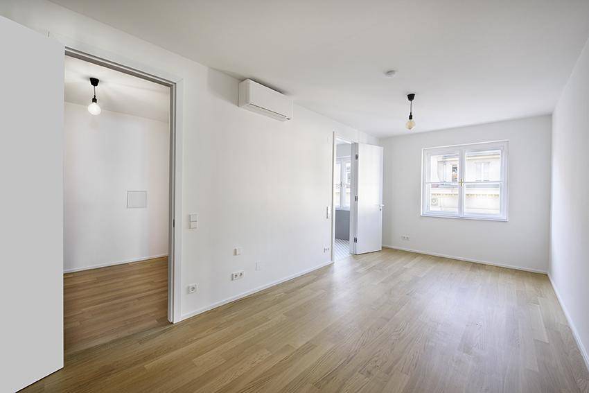 Geräumiges Zimmer mit Parkettboden und Fenster, vielseitig nutzbar.