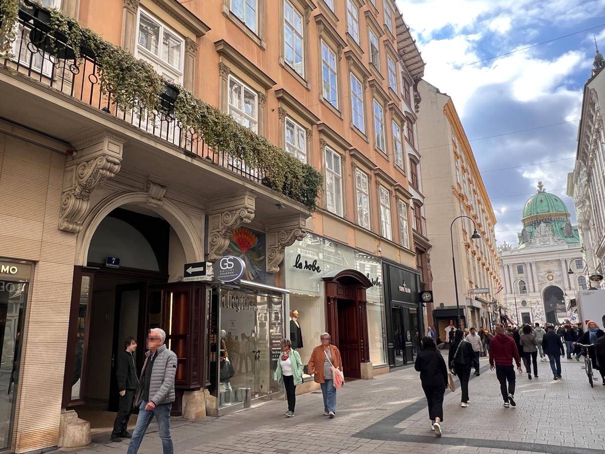 Belebtes Stadtbild mit historischer Architektur und Passanten auf der Einkaufsstraße.