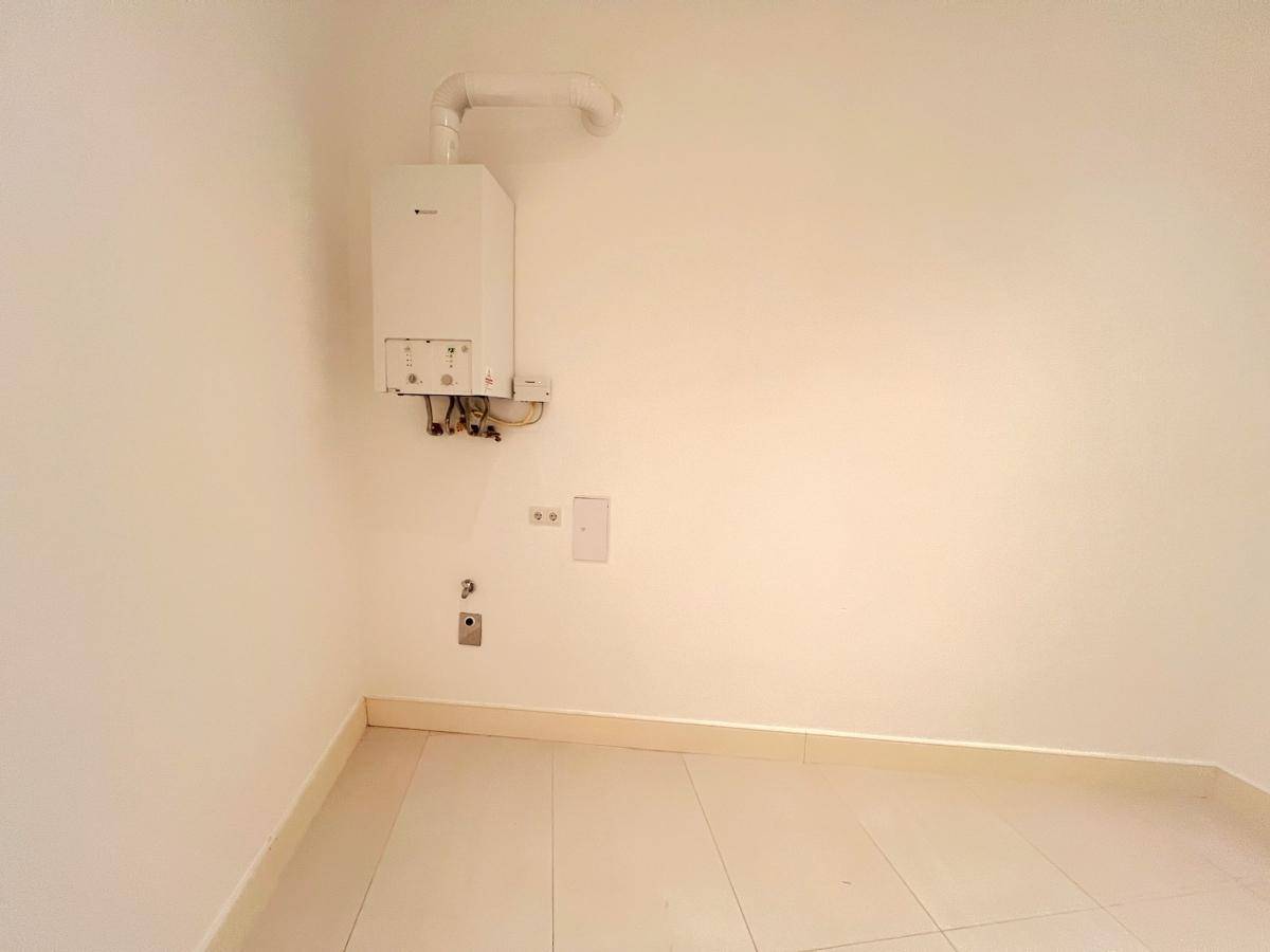 Praktischer Hauswirtschaftsraum mit Gastherme und pflegeleichtem Fliesenboden.