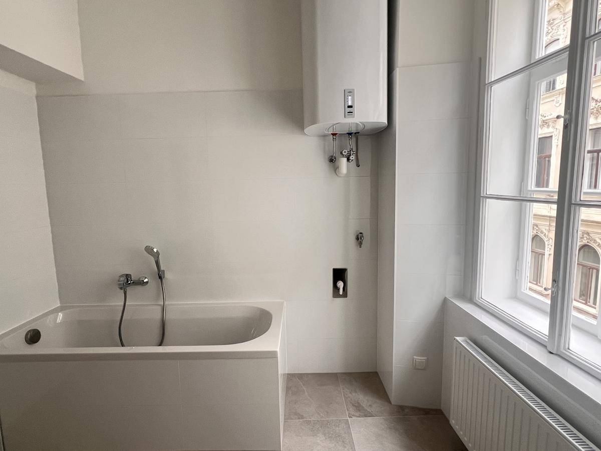 Modernes Badezimmer mit Badewanne und Wandheizkörper, bereit für die Endausstattung.