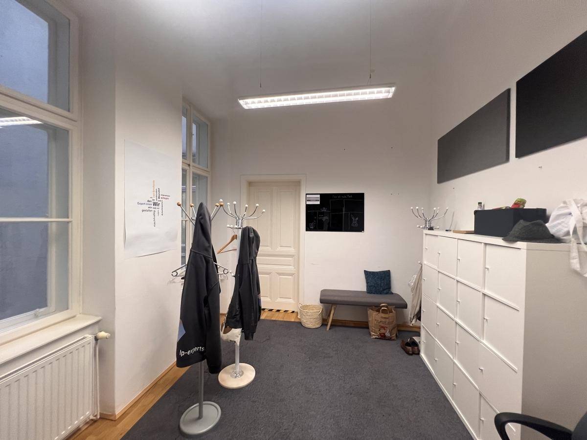 Eingangsbereich mit Garderobe, Schließfächern und Teppichboden, funktional und ordentlich.