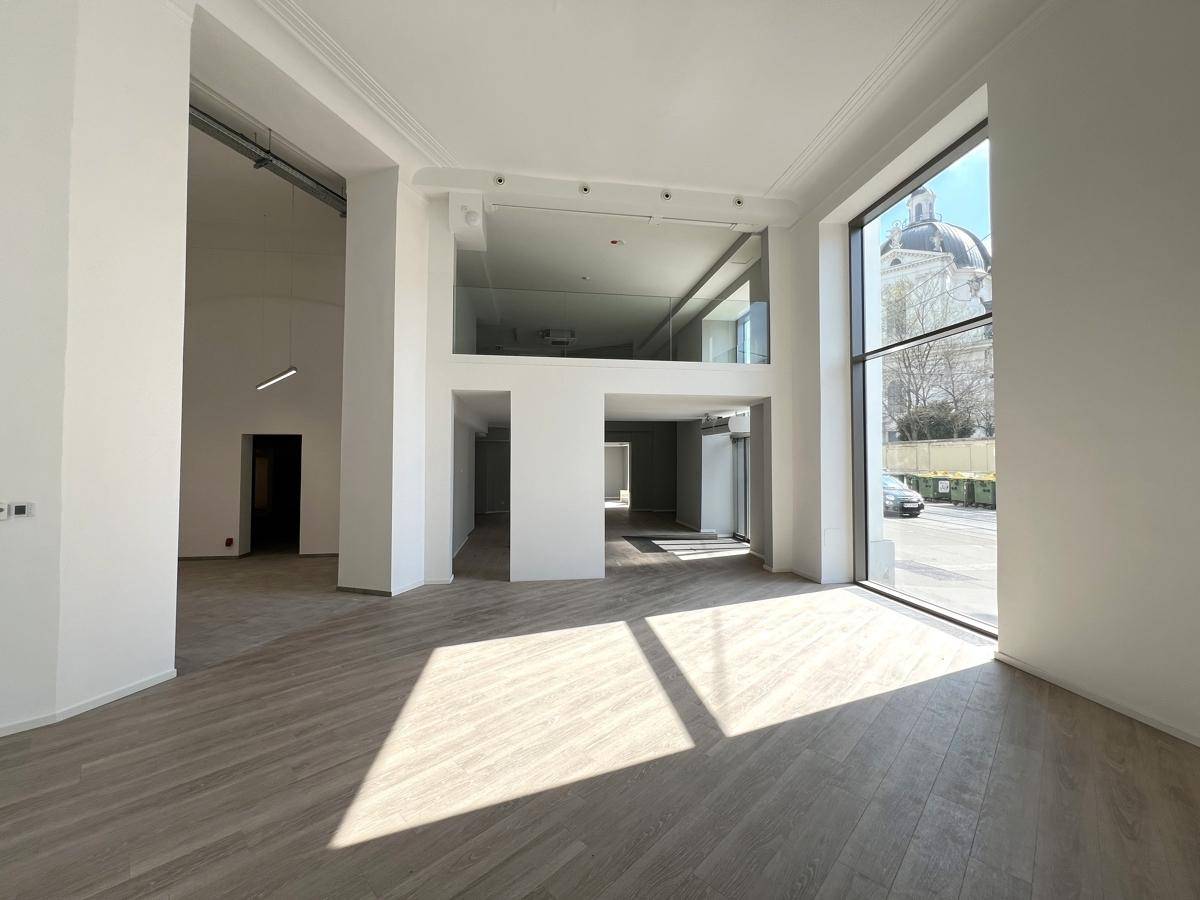 Heller, offener Gewerberaum mit hohen Decken, großen Fenstern und modernem Holzboden, bereit zur Nutzung.
