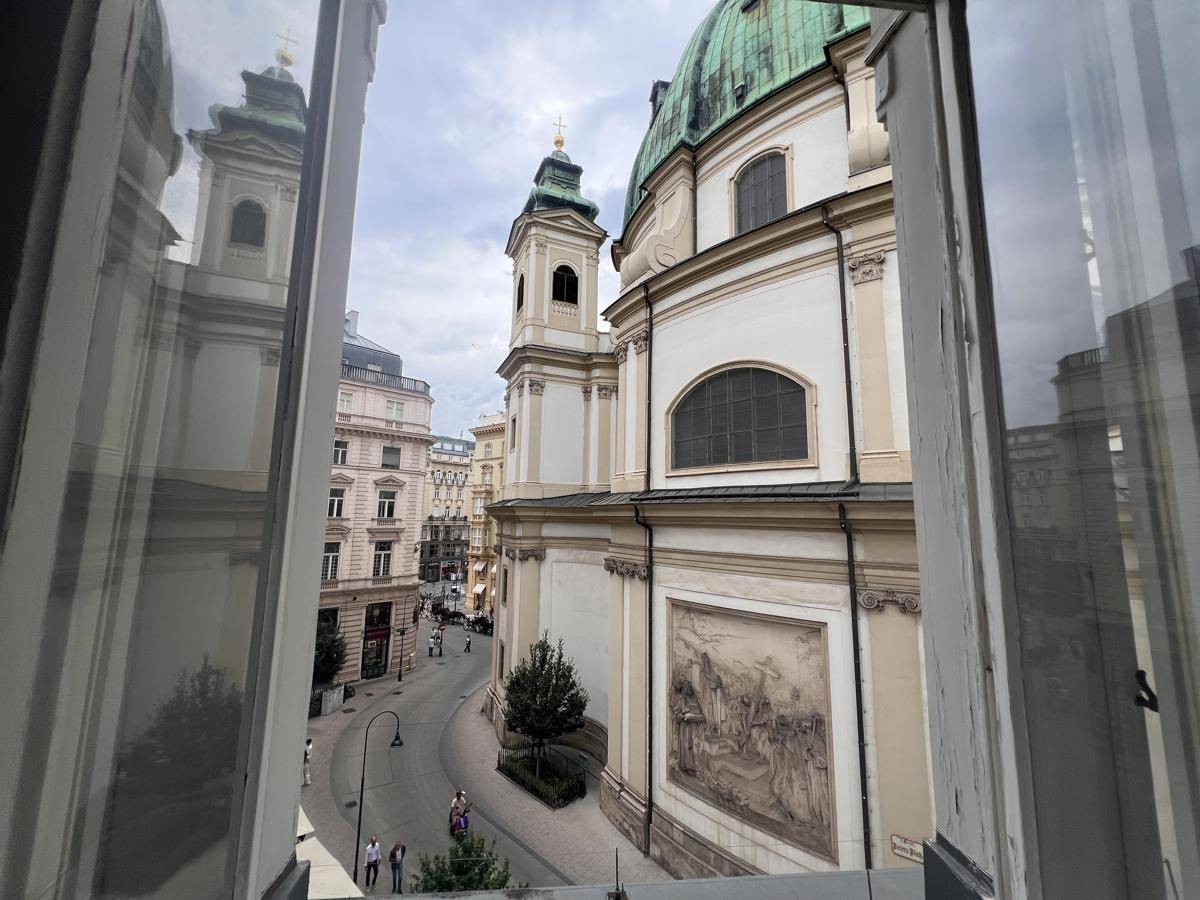 Blick aus dem Fenster auf eine historische Kirche und die belebte Straße, typisch für die Stadt.
