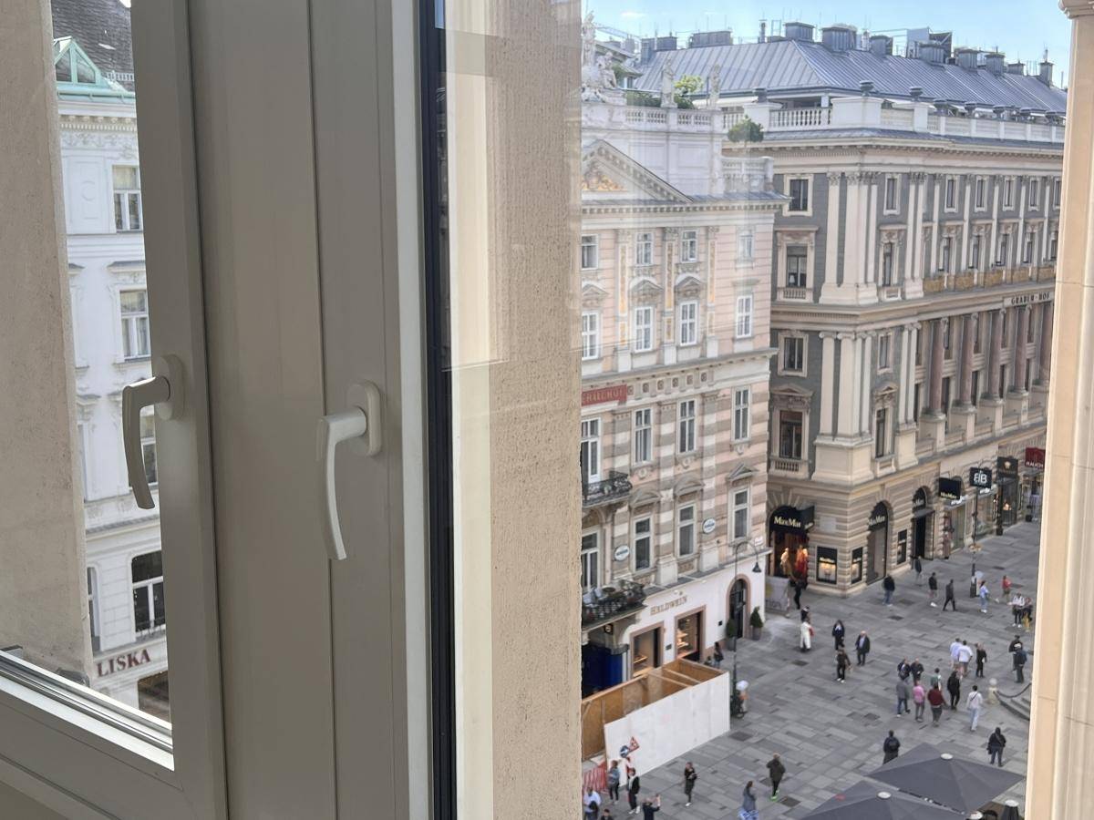Panoramablick aus dem Fenster auf die geschäftige Stadt mit ihren charakteristischen Gebäuden und Passanten.