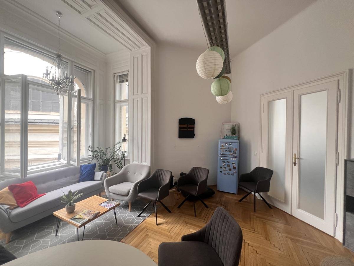 Geräumiger Bürobereich mit hohen Decken, Fischgrätparkett und großen Fenstern, modern eingerichtet.