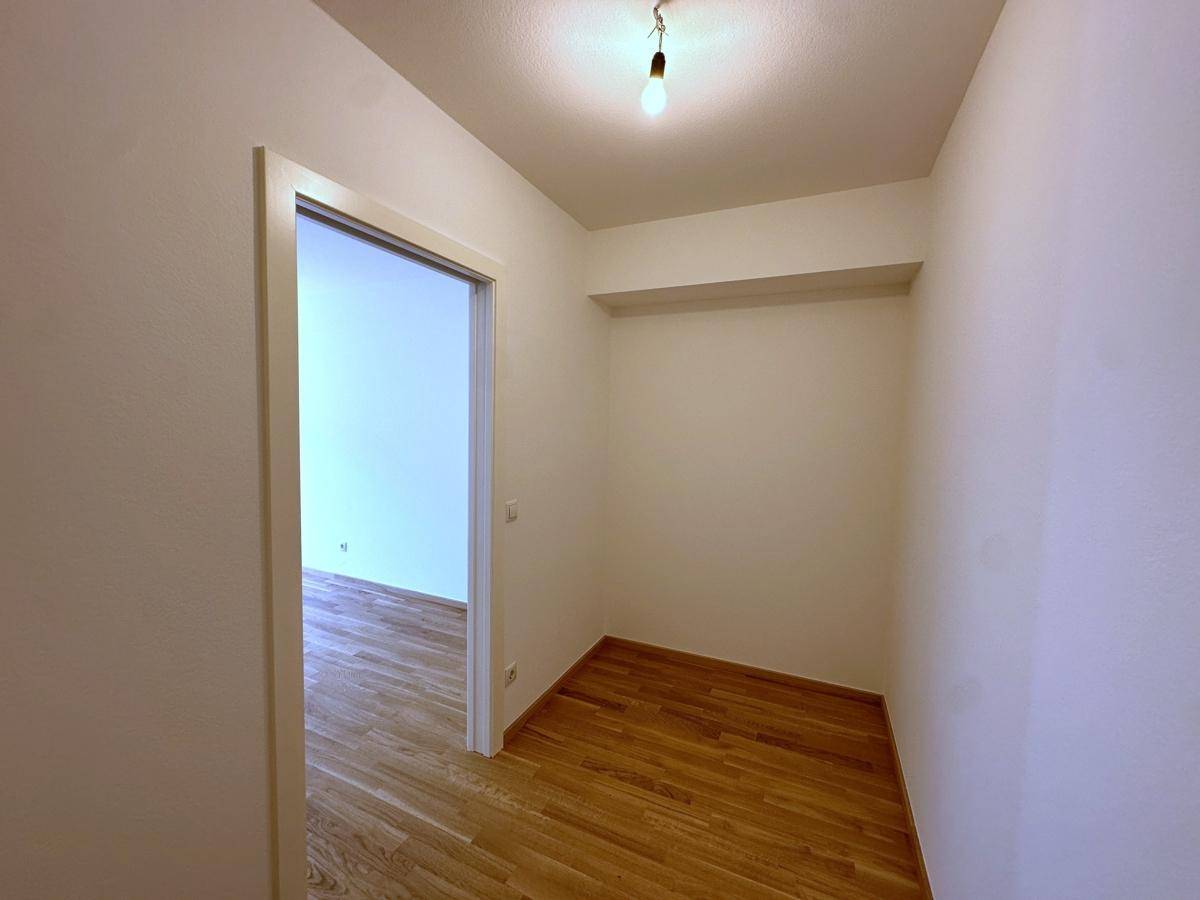 Kleiner, leerer Abstellraum mit Holzboden, ideal für zusätzlichen Stauraum.