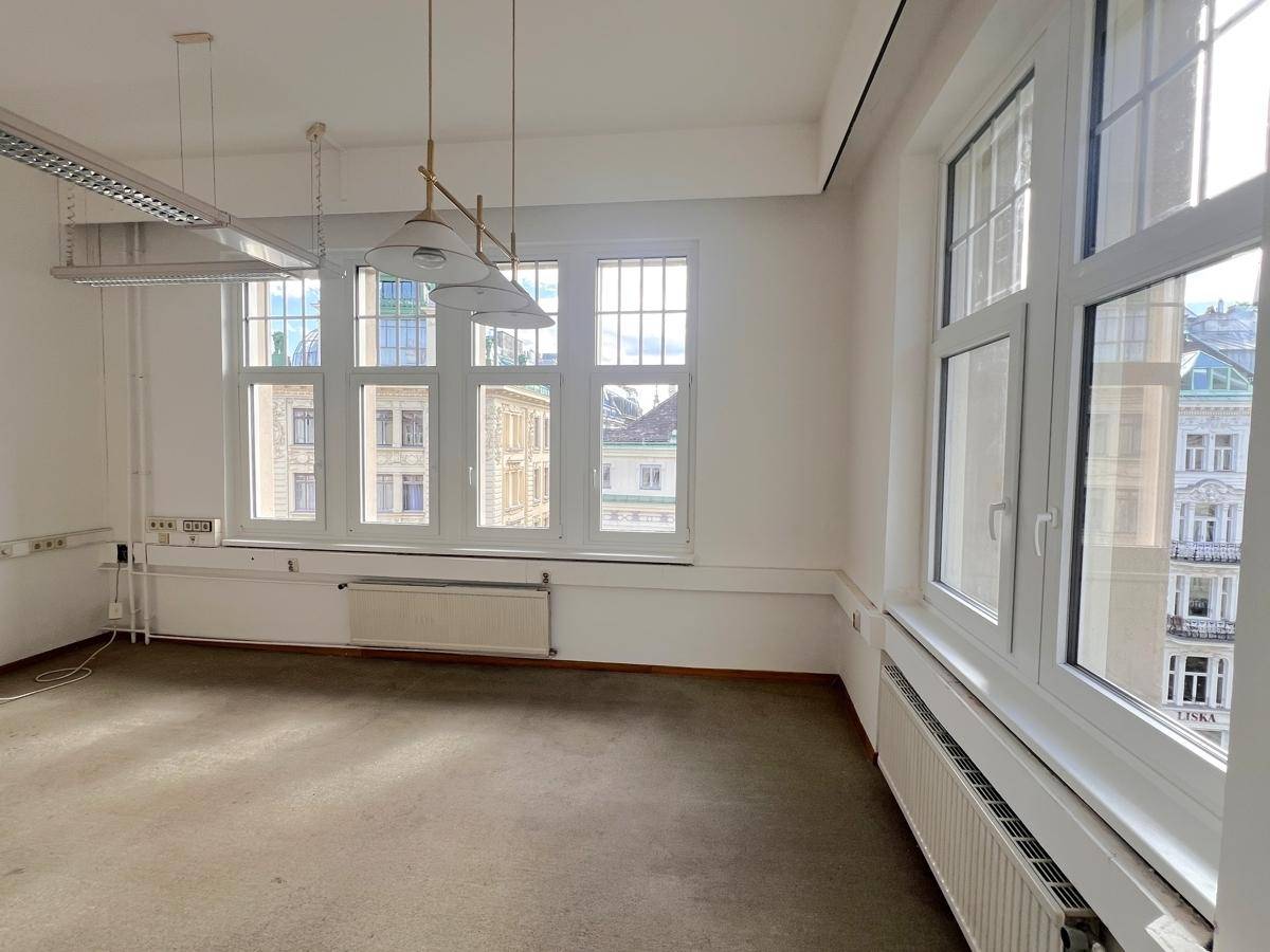 Großes, helles Büro mit vielen Fenstern, die einen weiten Blick bieten, und einem hellen Teppichboden.