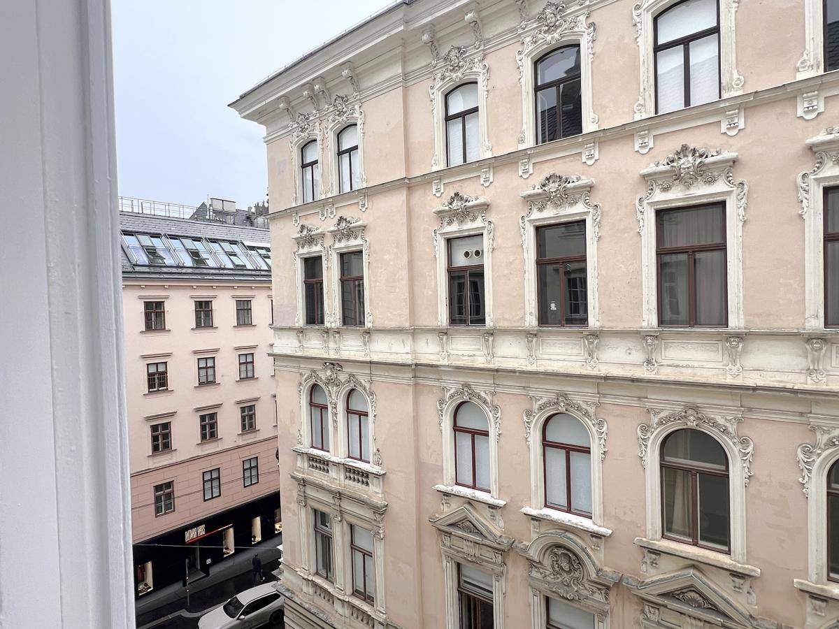 Blick aus dem Fenster auf die reich verzierte Fassade eines historischen Gebäudes.