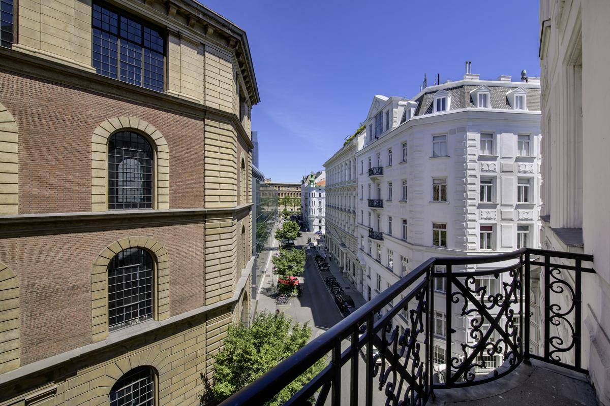 Blick vom Balkon auf eine belebte Straße und die umliegenden historischen Gebäude.