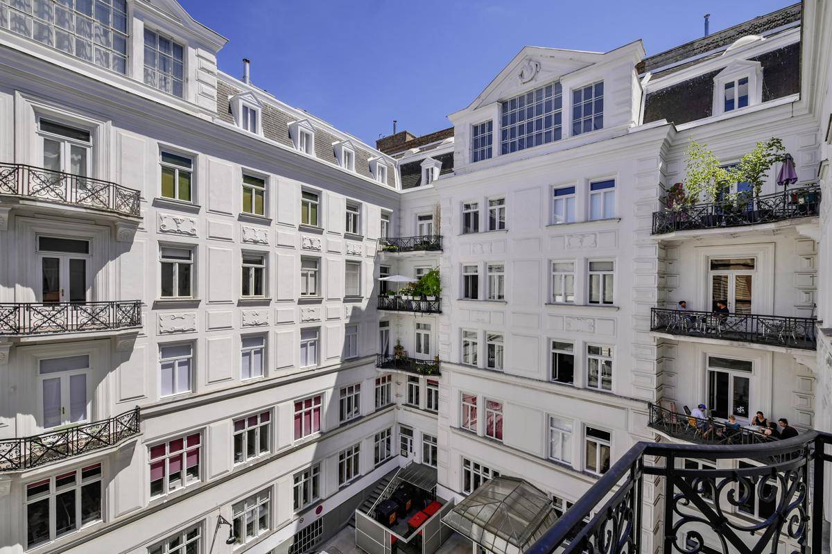 Historische Fassade eines Gebäudes mit vielen Fenstern und Balkonen.