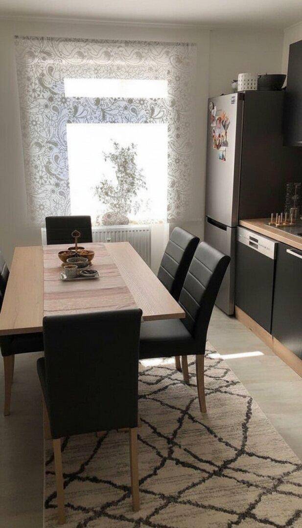 Heller Essbereich in der Küche mit modernem Teppich und Blick nach draußen durch das Fenster.