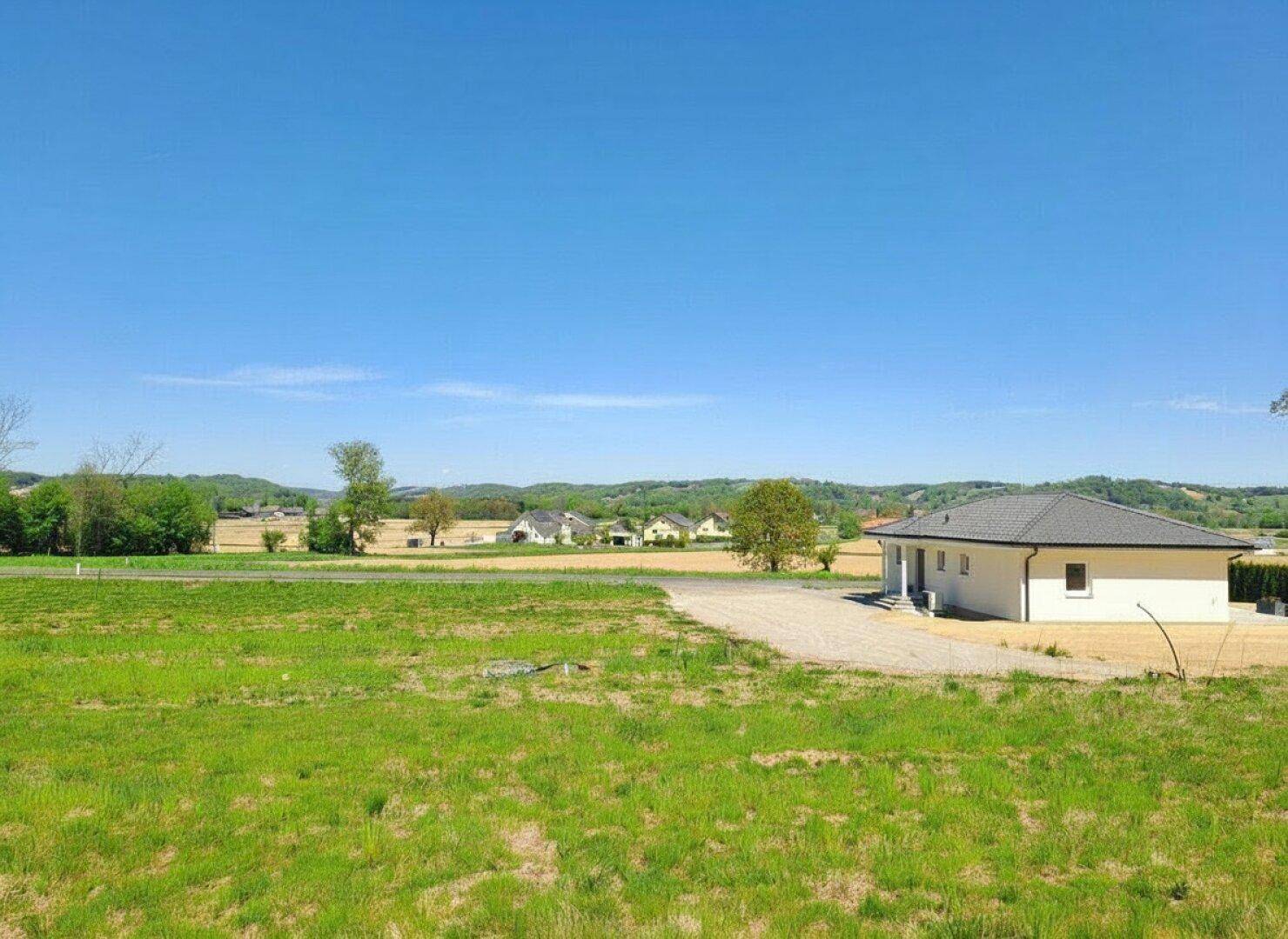 Weitläufiges Grundstück mit einem neuen Haus im Bau und Blick auf die umliegende Landschaft.