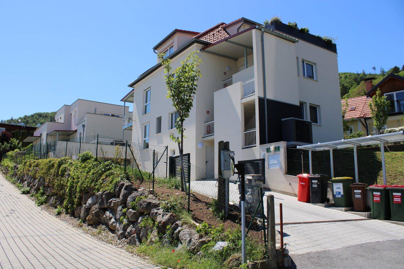 Modernes Mehrfamilienhaus mit gepflegter Außenanlage und Parkmöglichkeiten.