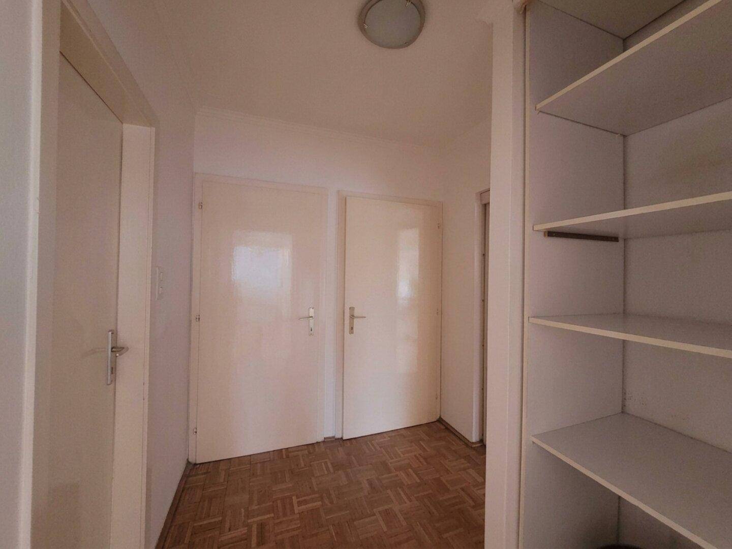 Kleiner Flur oder Abstellbereich mit Regalen und zwei Türen, ideal für zusätzlichen Stauraum.