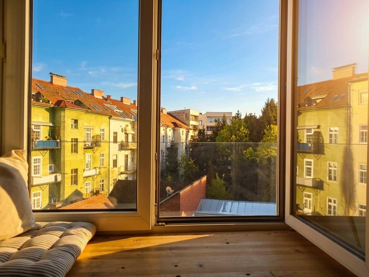 Malerischer Ausblick auf bunte Gebäude und grüne Bäume unter blauem Himmel, sonnig und weitläufig.