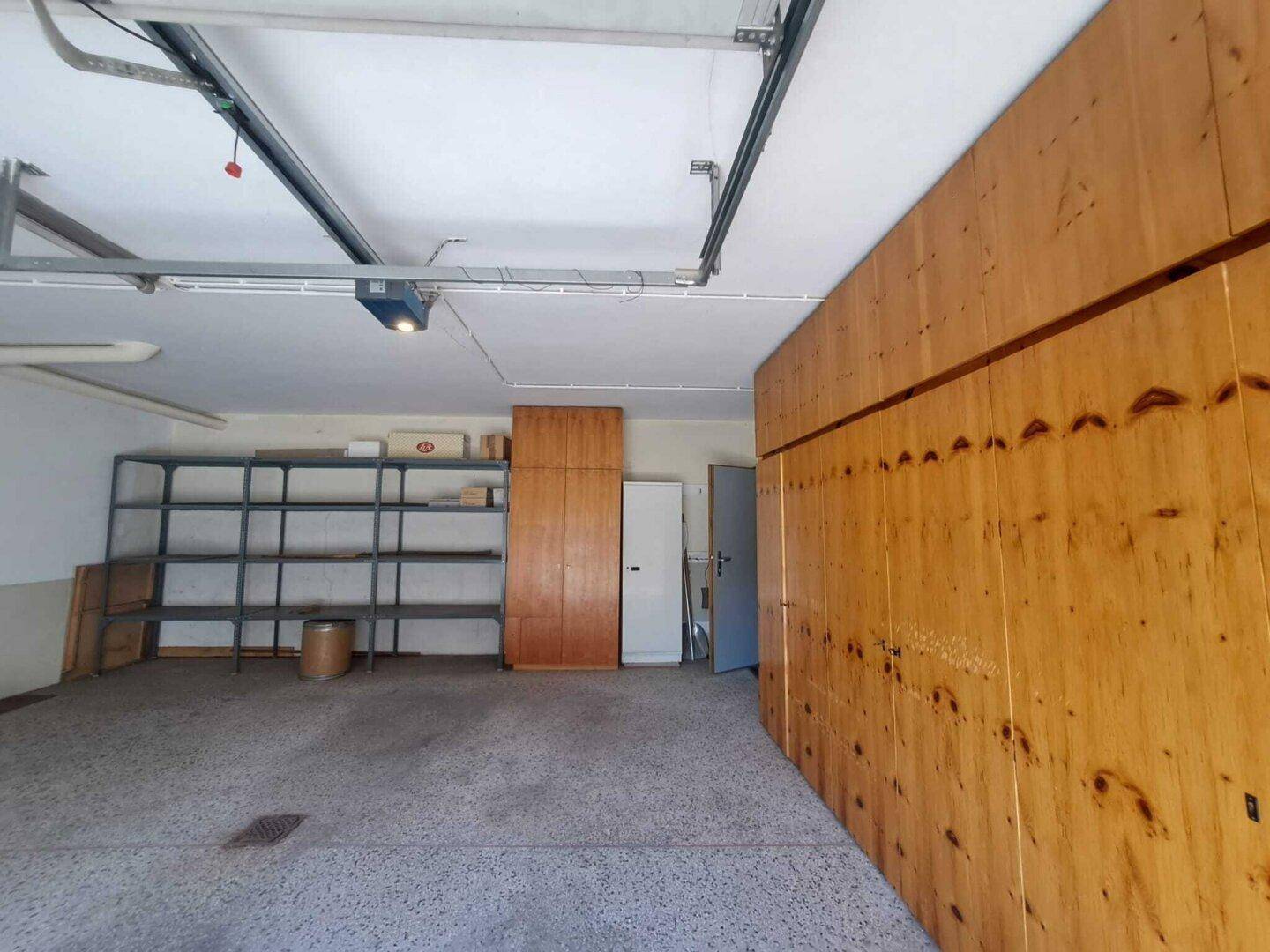 Geräumige Garage mit viel Stauraum und Holzverkleidung an einer Wand.