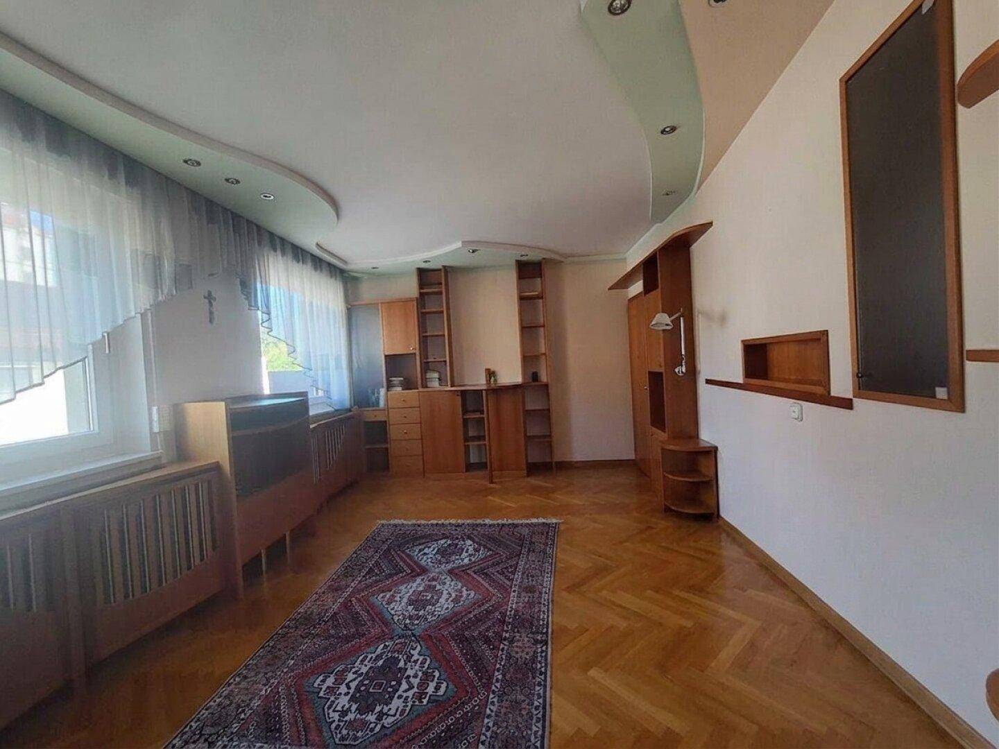 Helles Wohnzimmer mit Parkettboden und Einbauschränken, bietet viel Stauraum und Tageslicht.