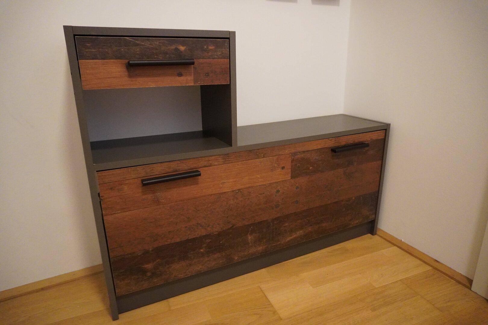 Rustikales Holzmöbelstück mit Schubladen und Ablageflächen, auf hellem Holzboden.
