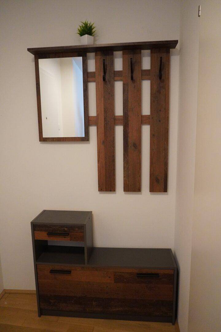 Eingangsbereich mit rustikaler Garderobe, Spiegel und passendem Schuhschrank.