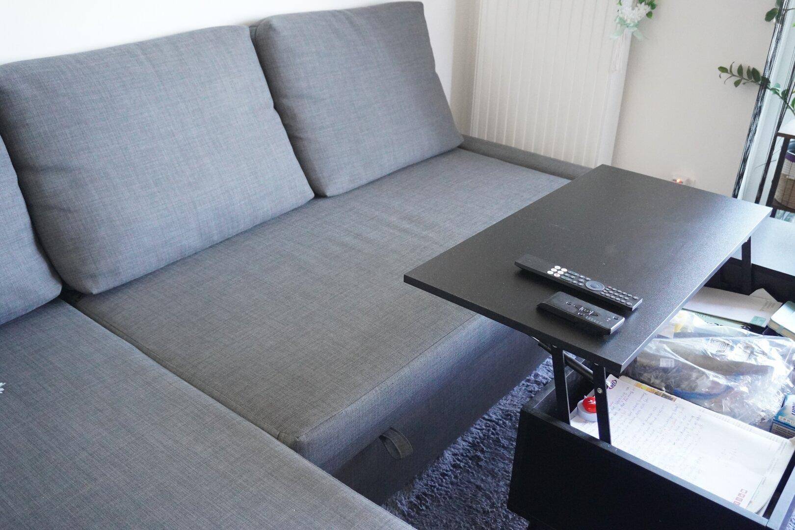 Detailansicht des grauen Ecksofas mit ausziehbarem Couchtisch und Stauraum.