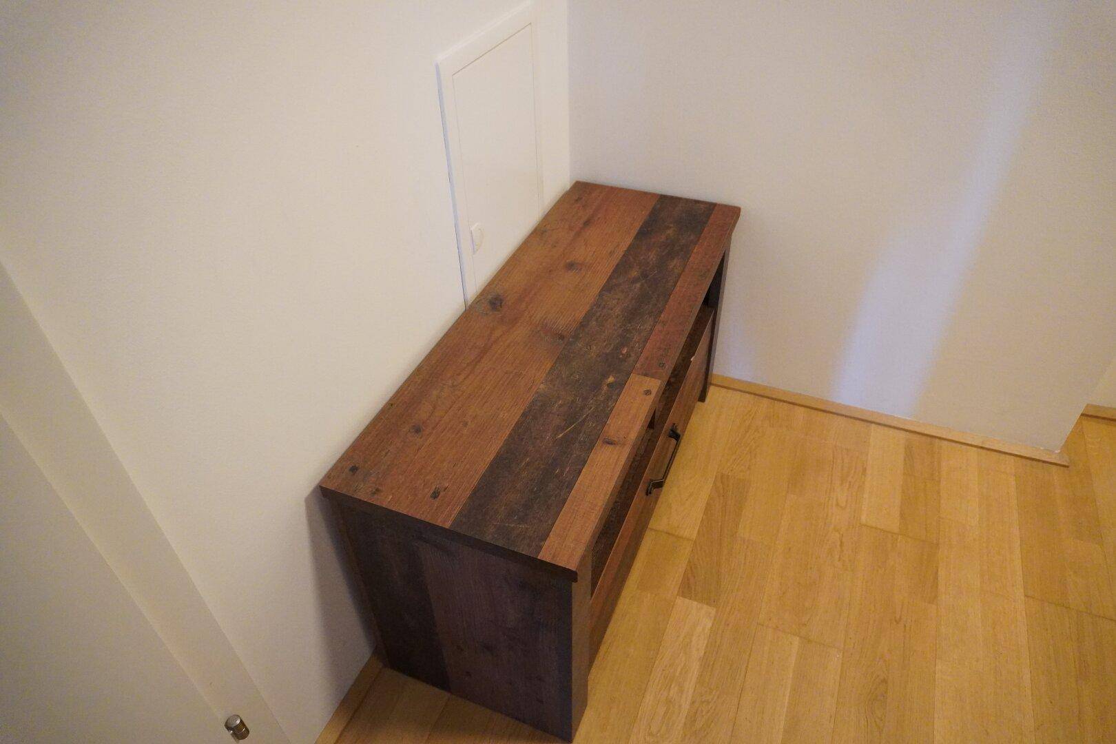 Langes Holzmöbelstück mit dunklen Akzenten, ideal für zusätzlichen Stauraum im Flur.