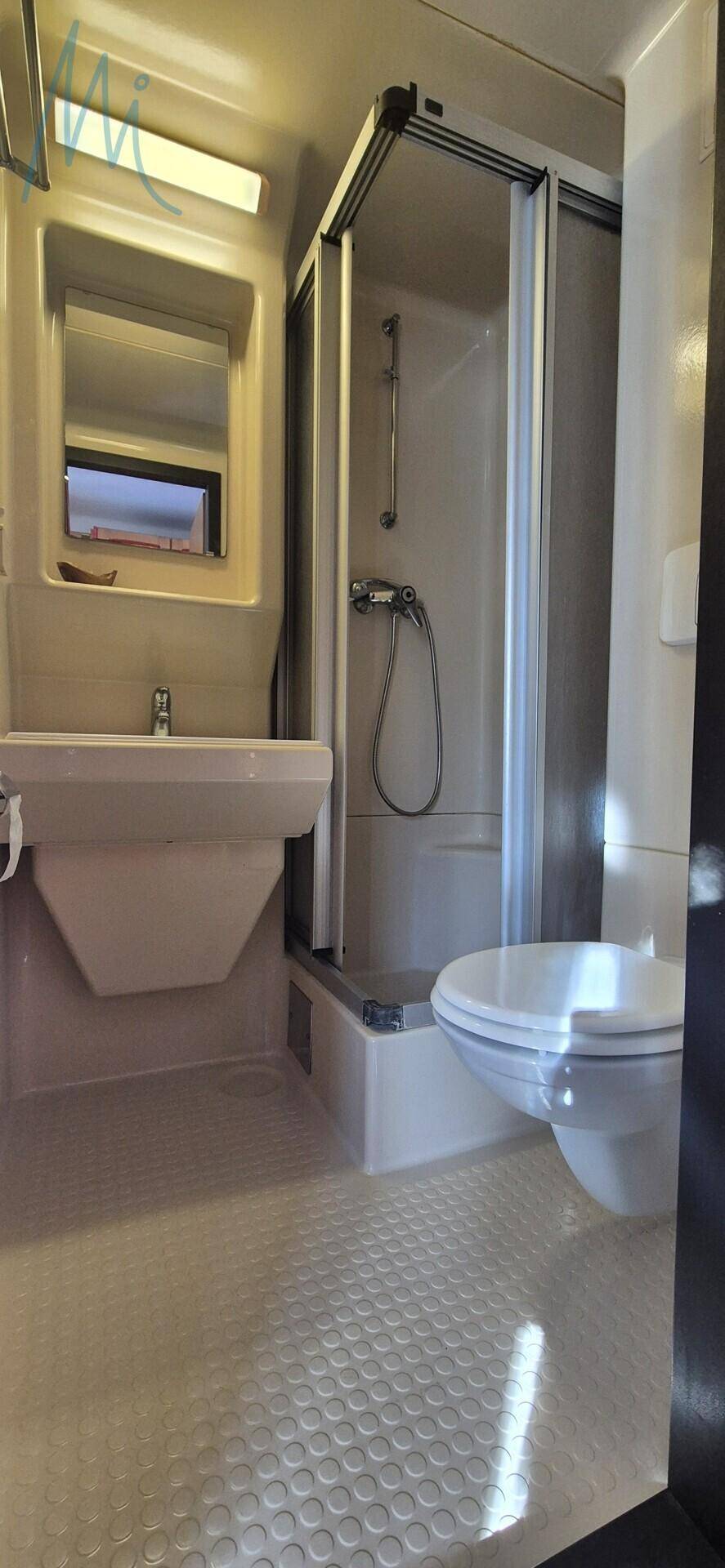 Modernes Badezimmer mit Duschkabine, WC und Waschbecken.