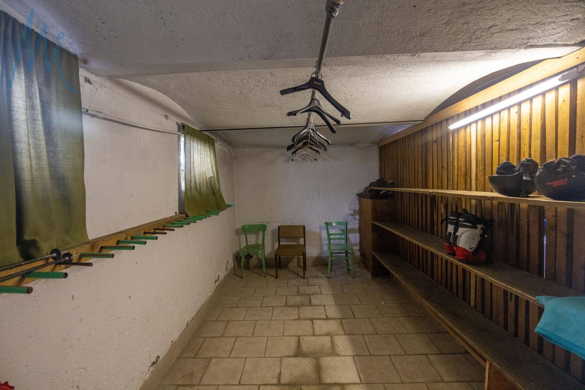 Praktischer Abstellraum mit Regalen und Kleiderbügeln, ideal zur Aufbewahrung von Sportausrüstung.