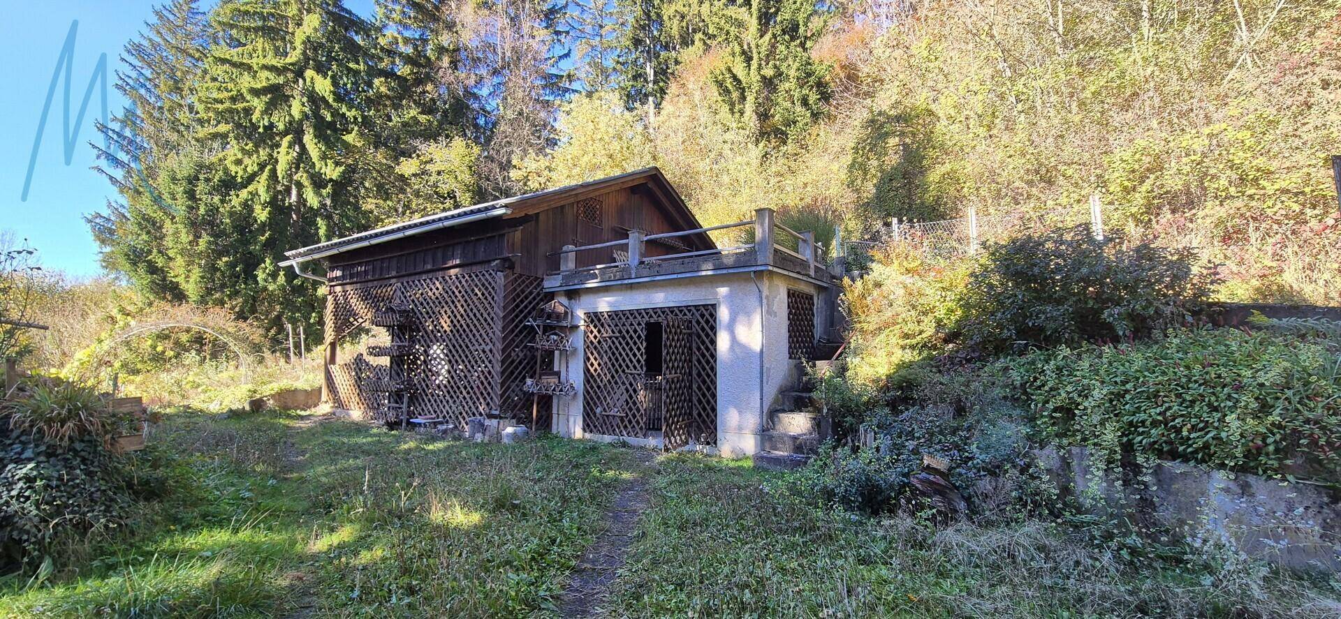 Nebengebäude mit Garage oder Schuppen und einer kleinen Terrasse im oberen Bereich.